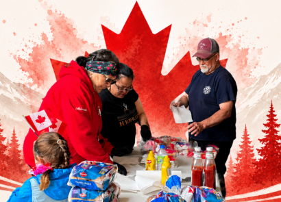Canada Day - Volunteers gather around a table of food and supplies inside the Hopedale fire hall